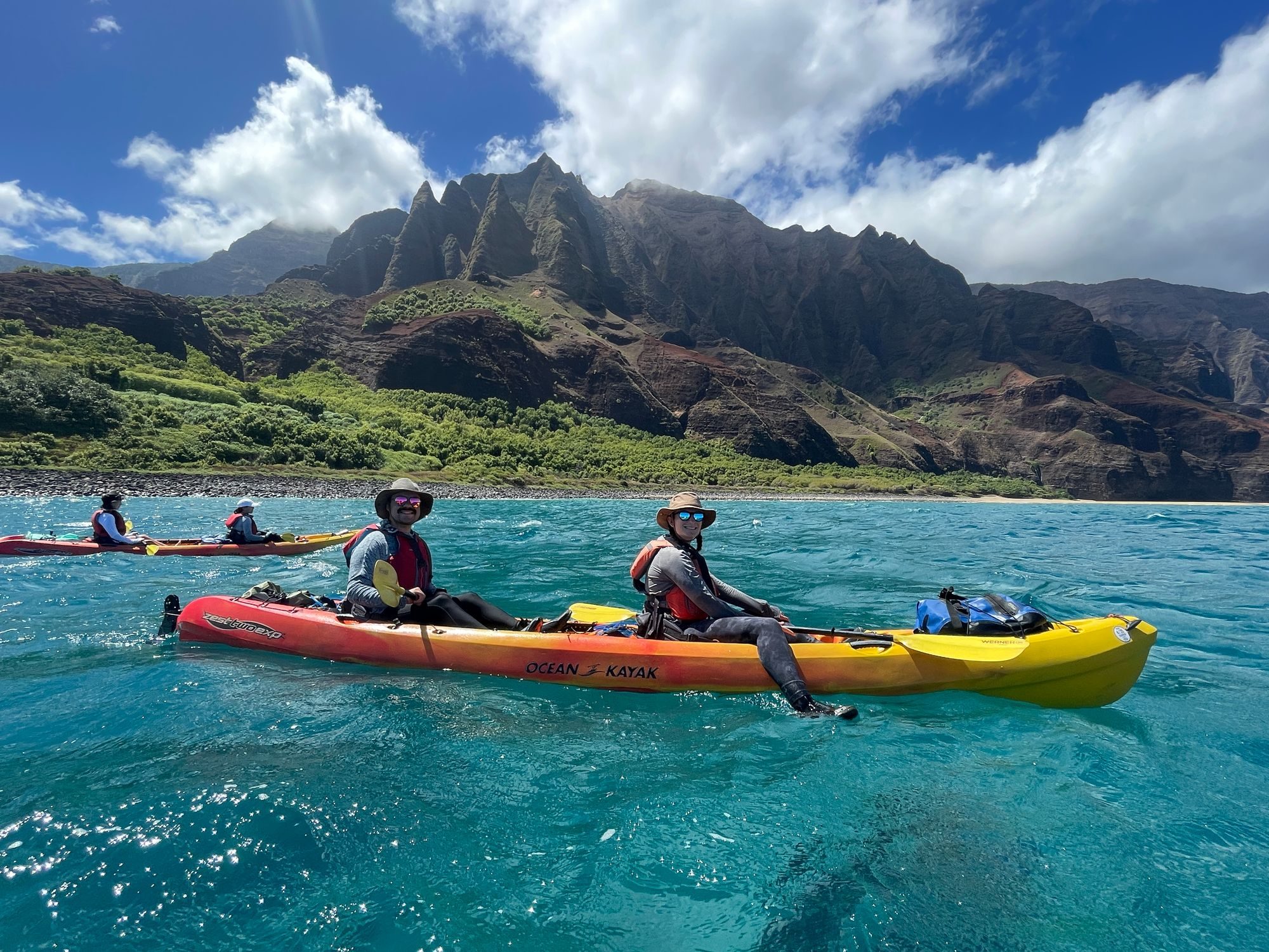 Kayakers paddling beneath the sea cliffs of the Na Pali Coast, Kauai